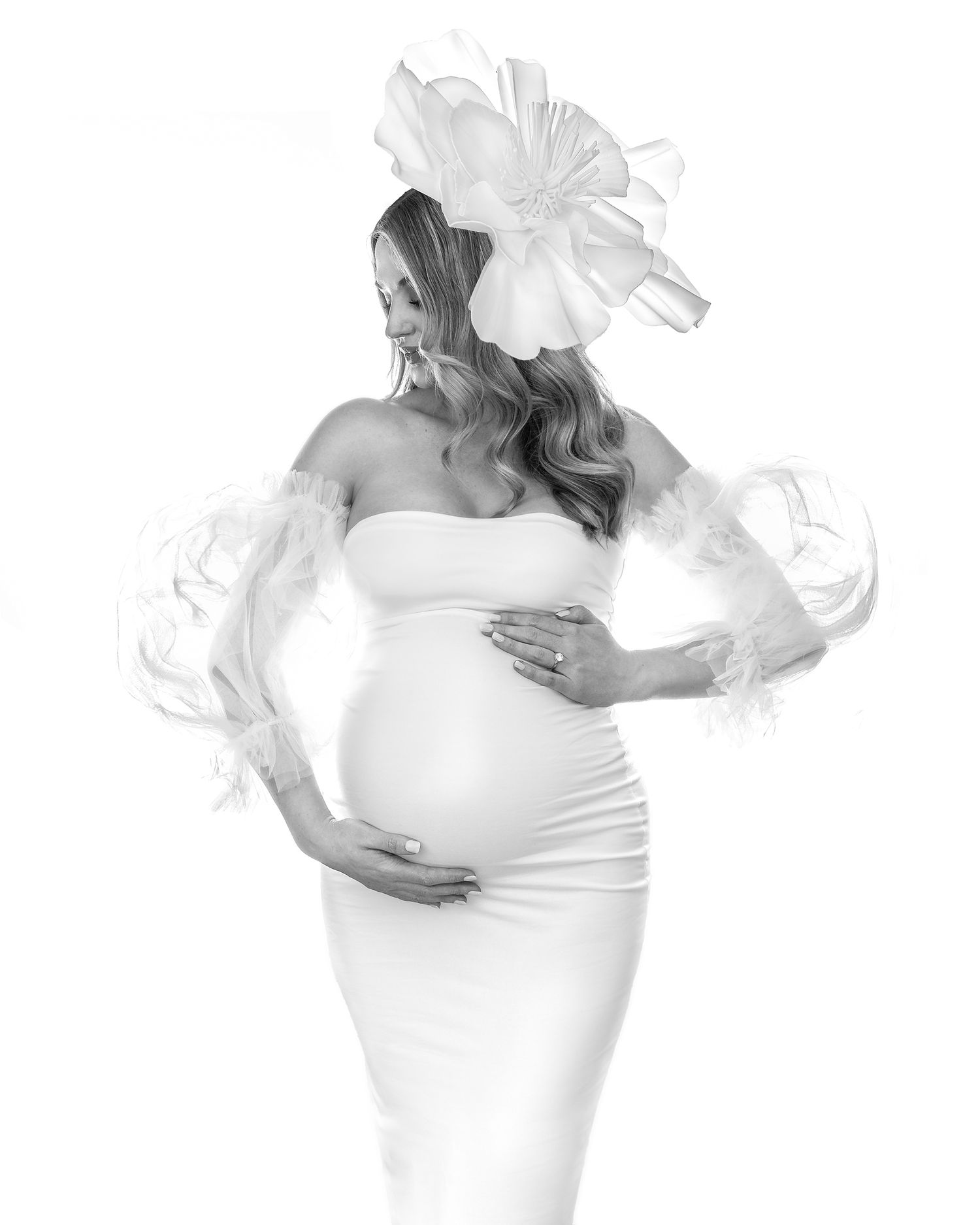 Woman in a white dress with dramatic sleeves and hat, high fashion studio portrait.