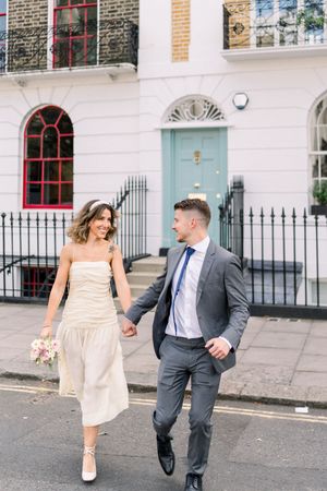 Playful and romantic newlyweds on colourful Central London street, captured by Nottingham wedding photographer with a light, airy style.