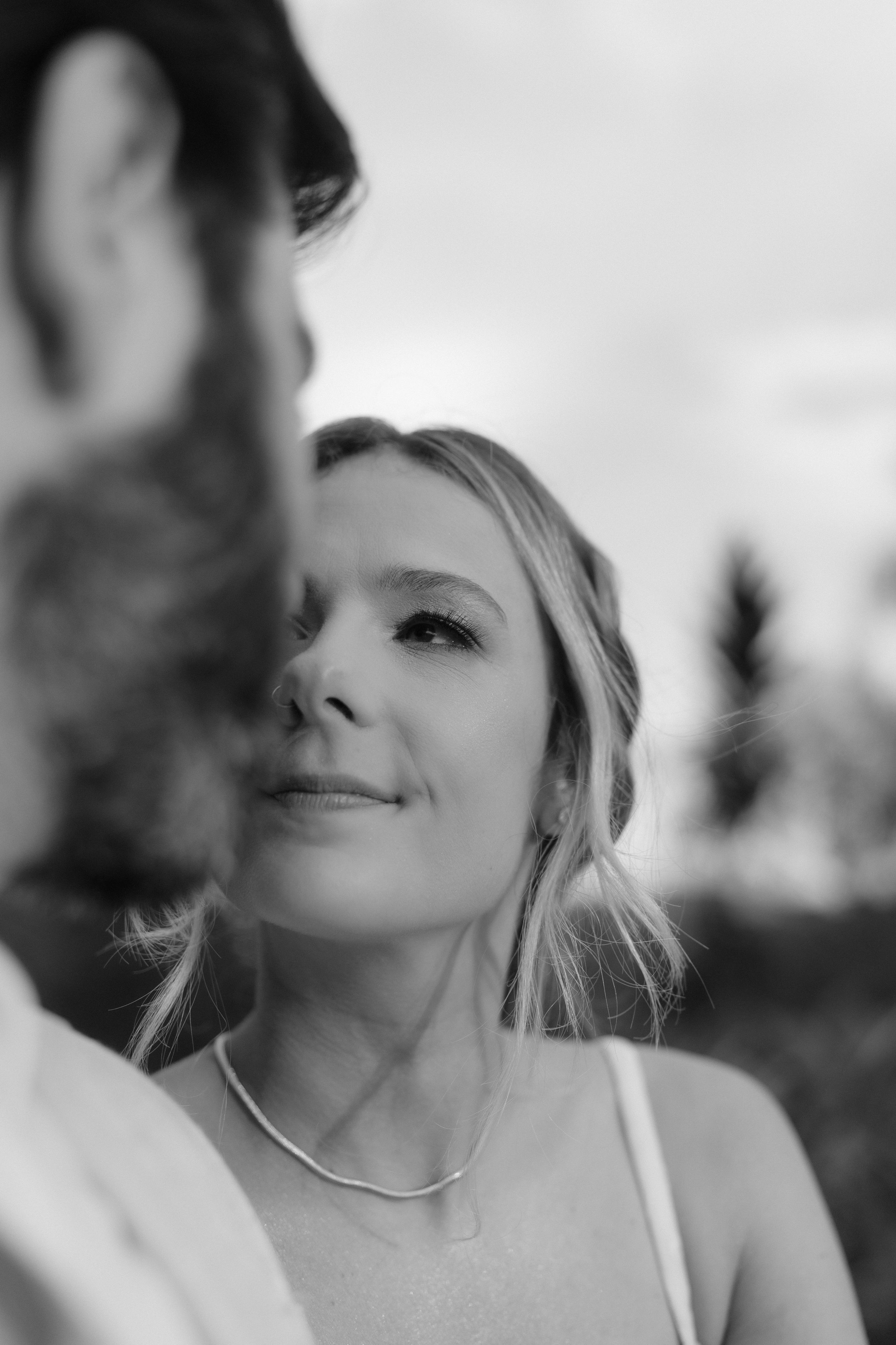 Black and white intimate portrait with delicate necklace detail.