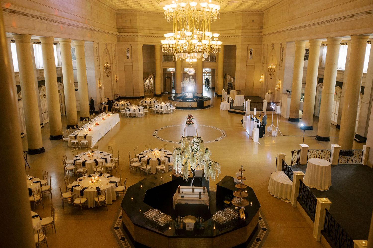 Elegant ballroom with crystal chandelier and circular layout of wedding reception tables in a grand historic venue at Hall of Springs.