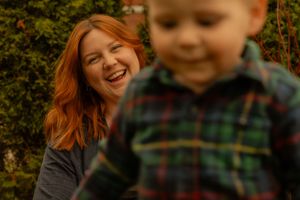 Candid spring family photo in Hamilton — joyful moment between mom and child in plaid during an outdoor lifestyle session.