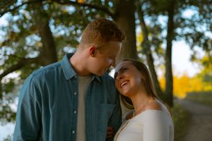 Princess Point Hamilton engagement session in fall — romantic couple sharing a quiet moment under golden trees during golden hour.