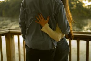 Cozy golden hour moment during a Princess Point couples session in Hamilton— intimate embrace on a wooden deck at sunset.