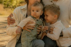 Golden hour outdoor family session in Hamilton — candid moment of parents with children in soft, neutral tones.