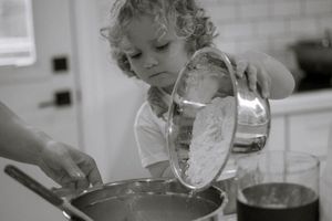 Lifestyle family photography in Stoney Creek — child baking in a cozy kitchen during an in-home session.