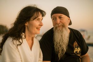 Candid portrait of couple outdoors in warm light — relaxed beach session capturing personality and connection.