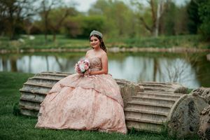 A flowing pink dress photographed along stone steps near a serene pond.