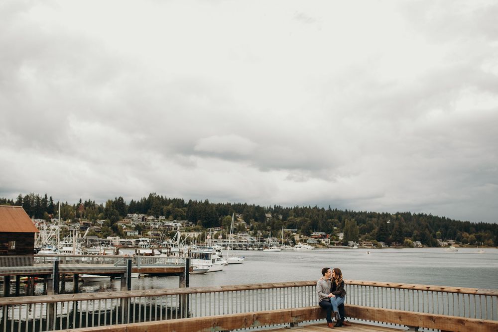 A scenic view of a marina with boats docked along the waterfront in Gig Harbor on an overcast day.