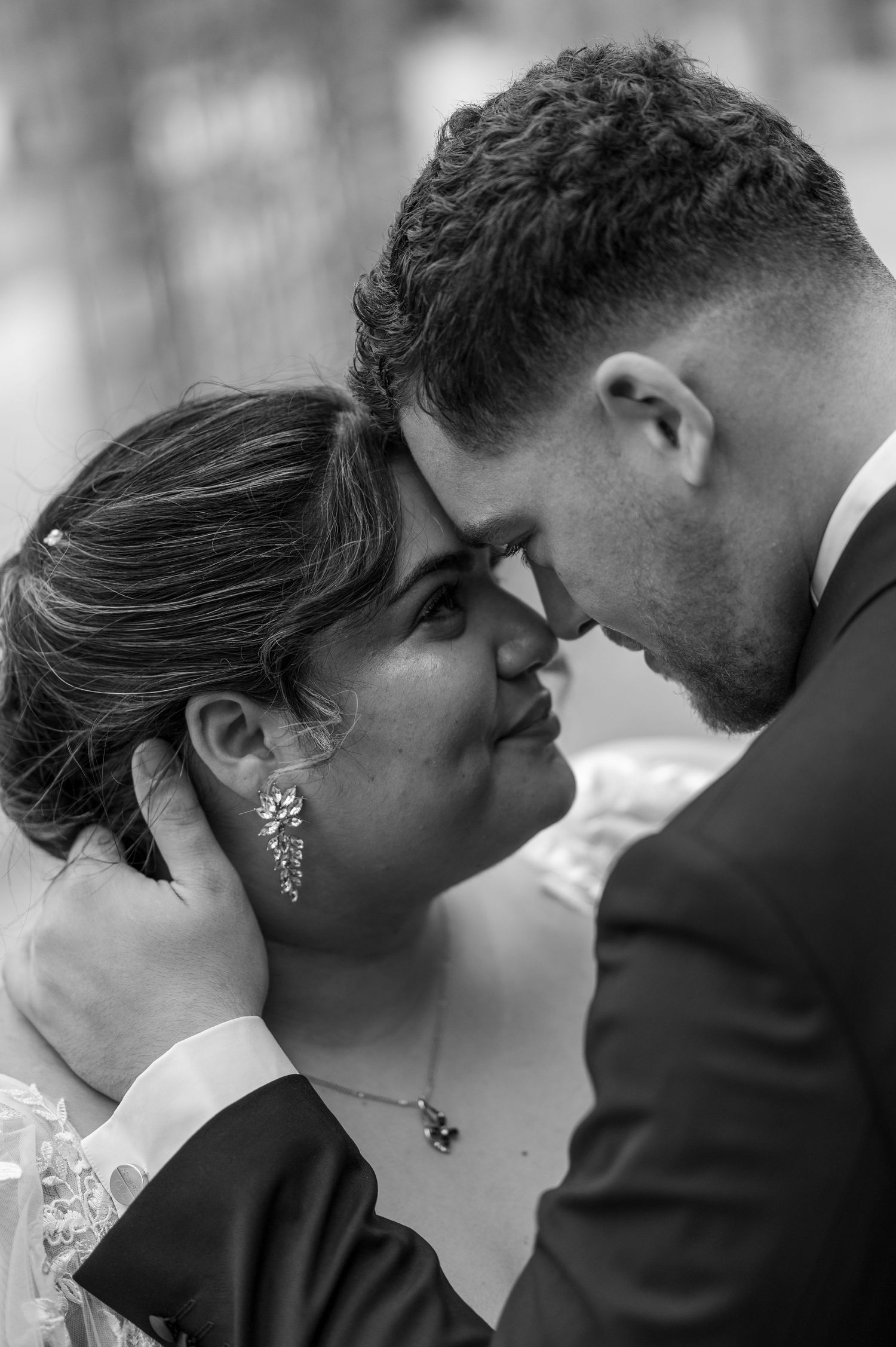 Une séquence de photos de mariage en noir et blanc montre un moment tendre entre un couple sur le point de partager un baiser romantique.