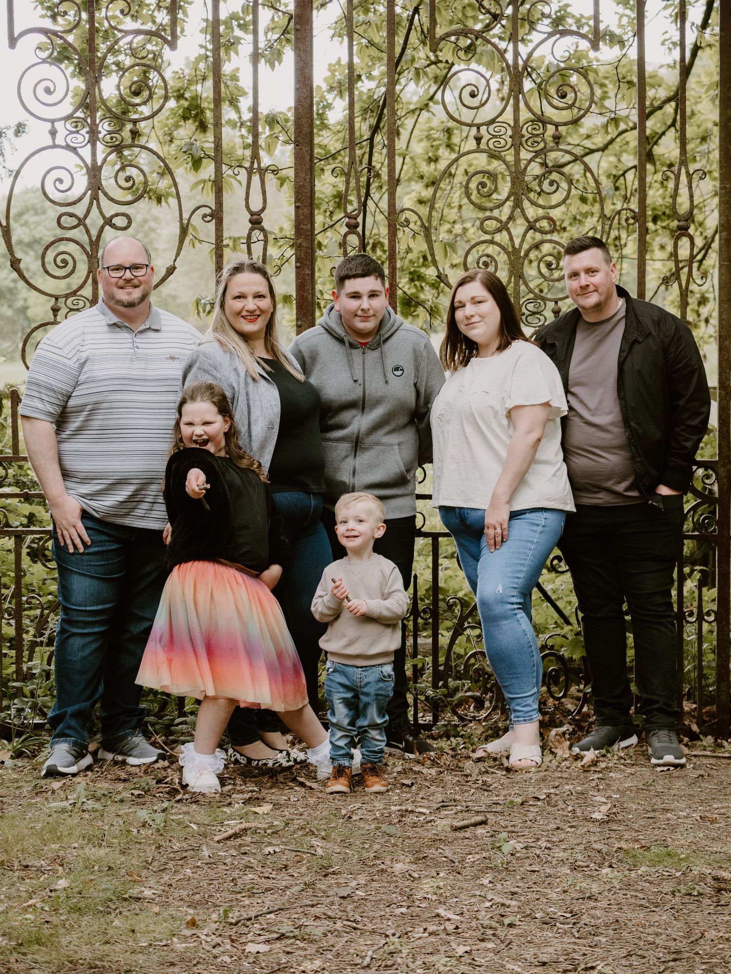 Wortley Hall - Family group photo outdoors with decorative iron fence and trees in background.
