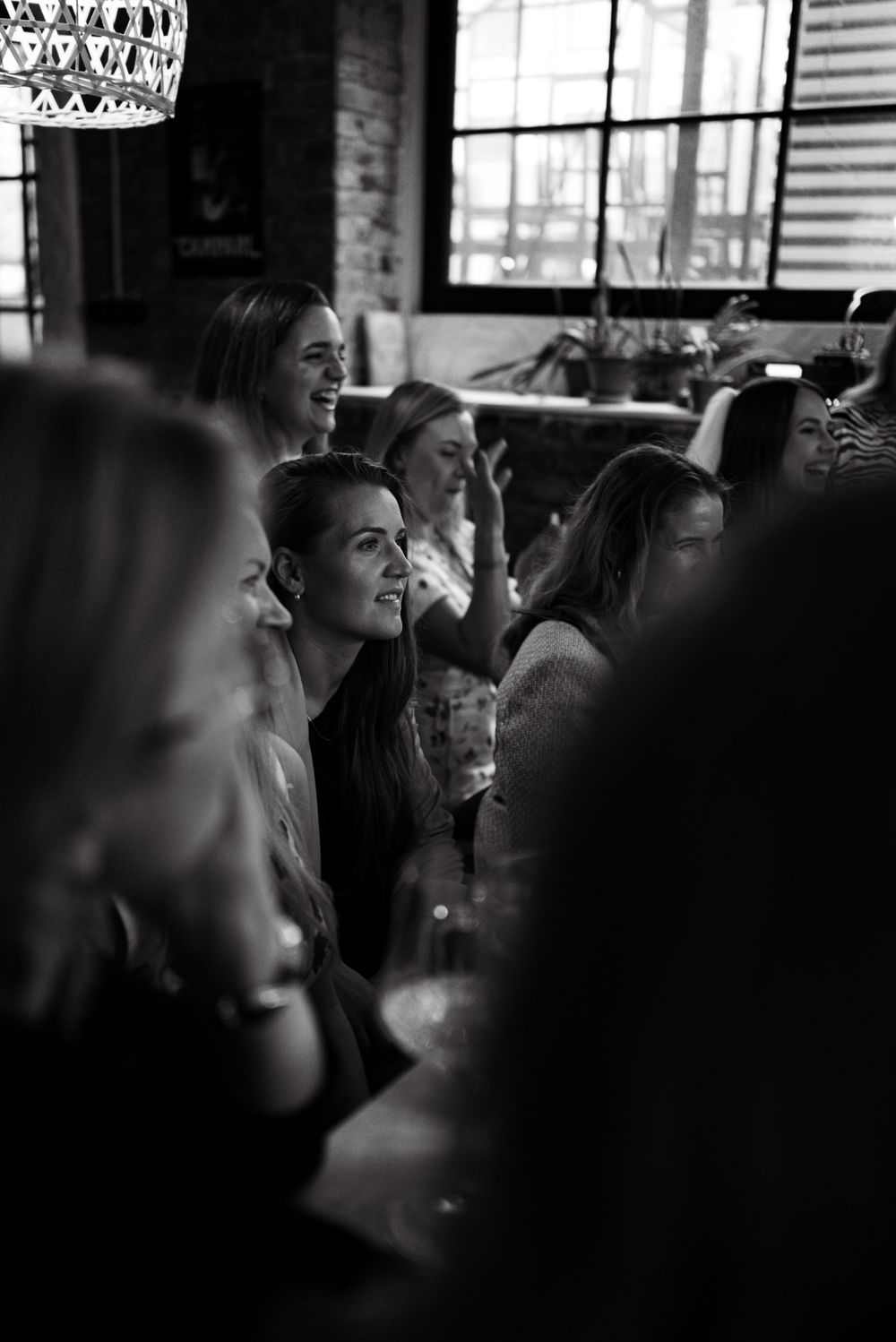 Black and white photo set showing multiple frames of a person laughing in a candid sequence.