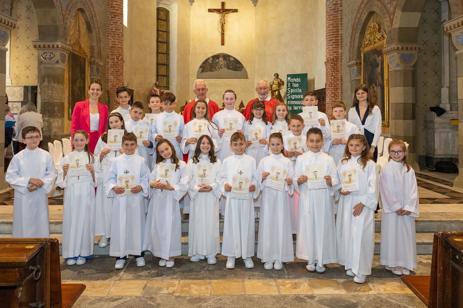 A group stands together in front of an altar with a crucifix in a traditional church setting.