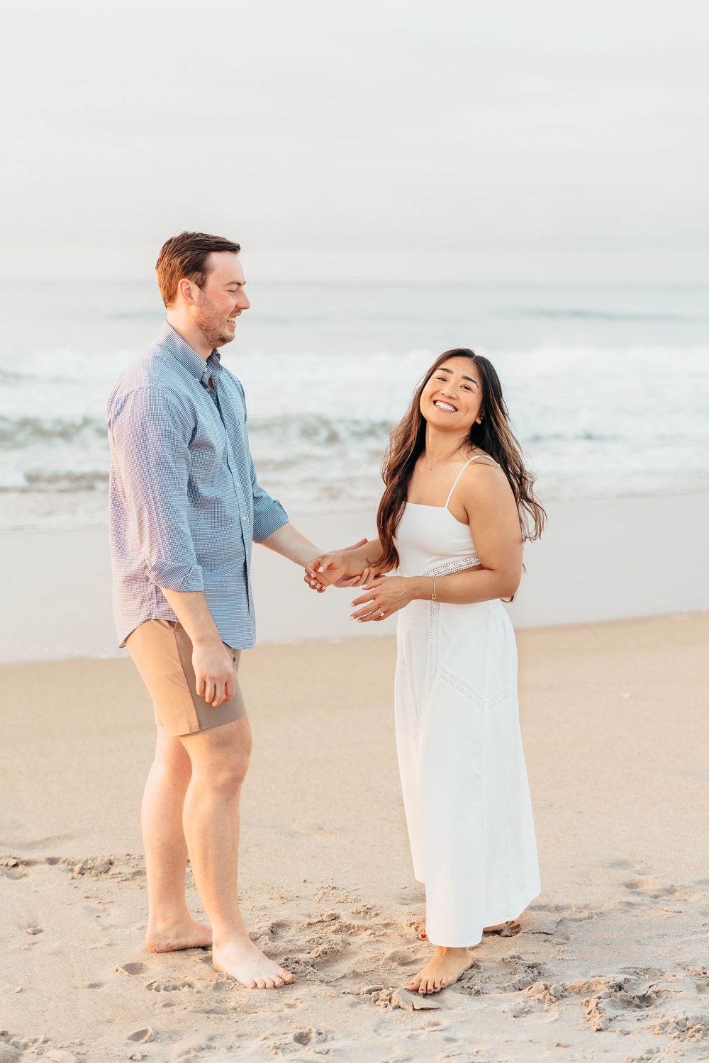 Playful couple dancing and laughing together on sandy beach at sunset. Wilmington NC. Wrightsville beach.