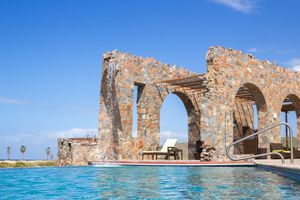 Stone ruins architecture surrounding a luxurious infinity pool overlooking the ocean. El Faro by Guaycura.