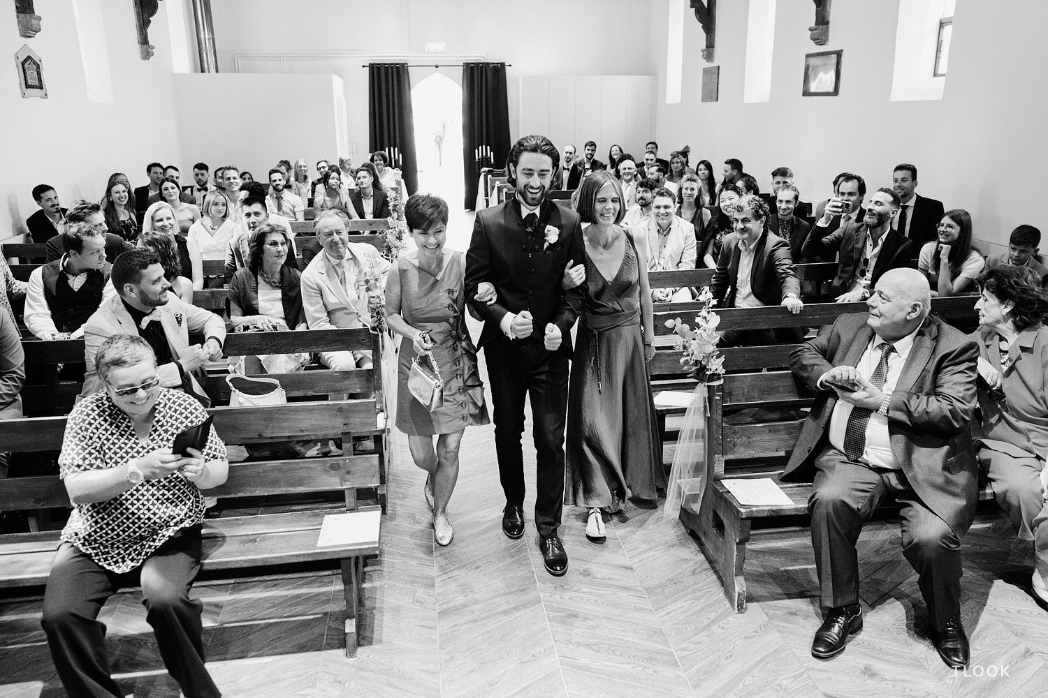 TLOOK photographe de mariage de style documentaire, au royalp de villars cérémonie religieuse le marié entre avec sa maman