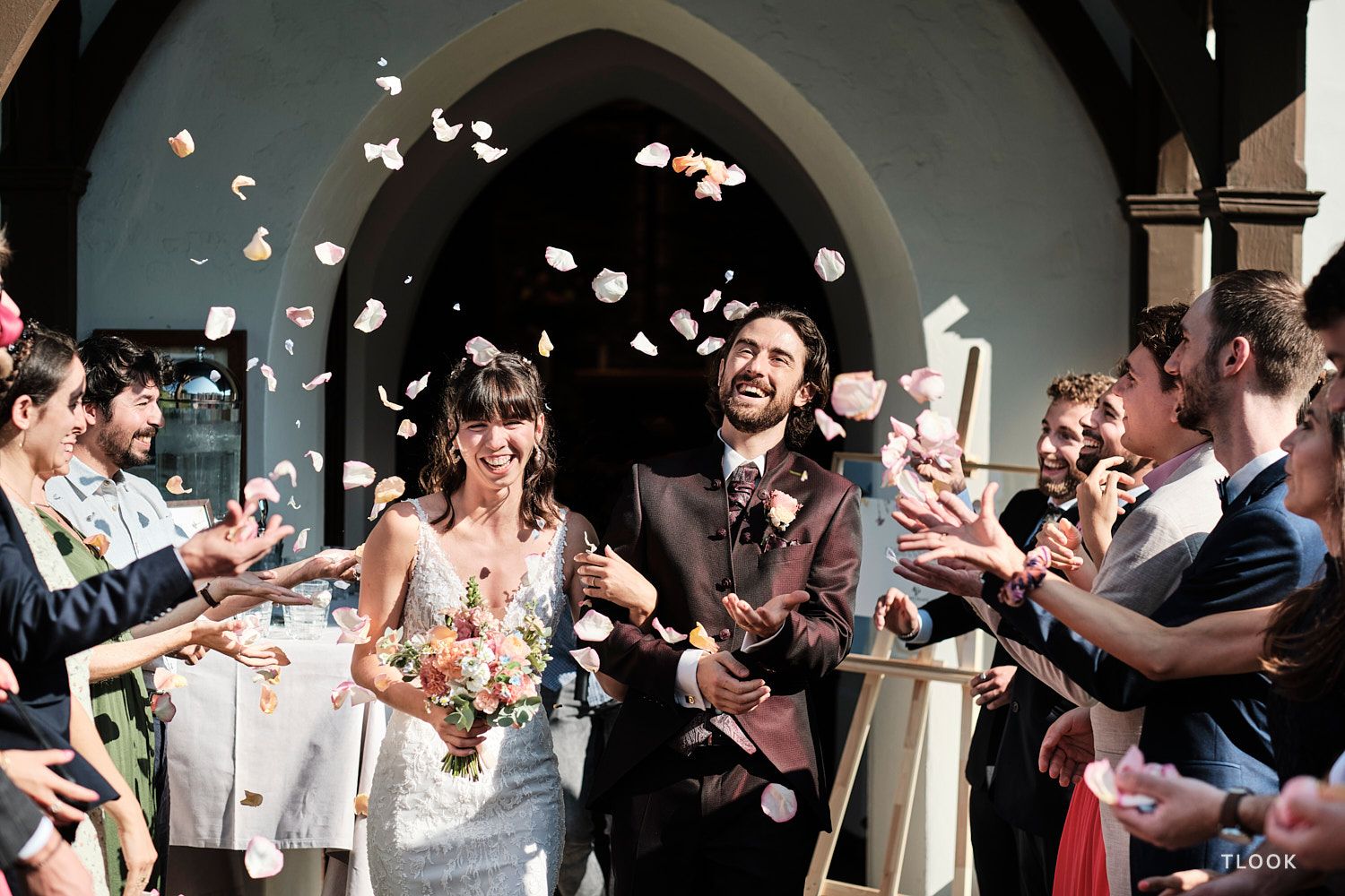 TLOOK photographe de mariage de style documentaire, au royalp de villars fin de la cérémonie les mariés sortent pétales de fleurs
