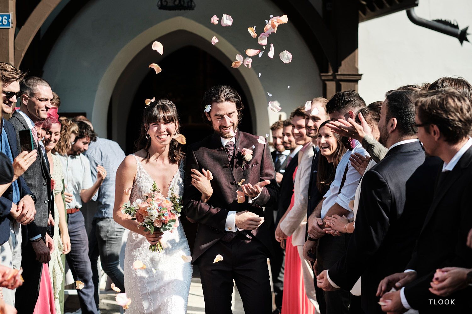 TLOOK photographe de mariage de style documentaire, au royalp de villars fin de la cérémonie les mariés sortent pétales de fleurs