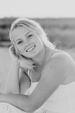 Black and white portrait of a person smiling with backlit hair.