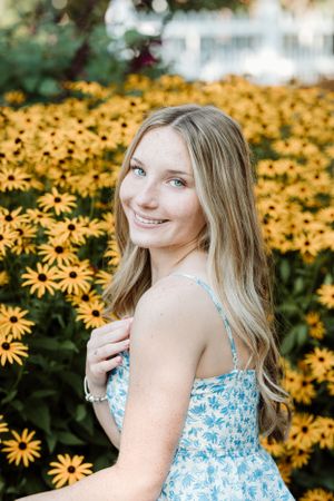 Portrait in a garden with vibrant yellow Black-Eyed Susan flowers in full bloom.