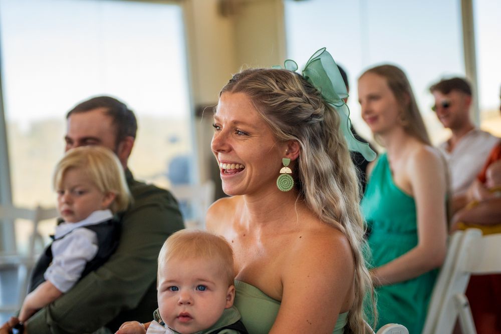 An emotional wedding reception scene shows guests and a small child sharing joyful moments.