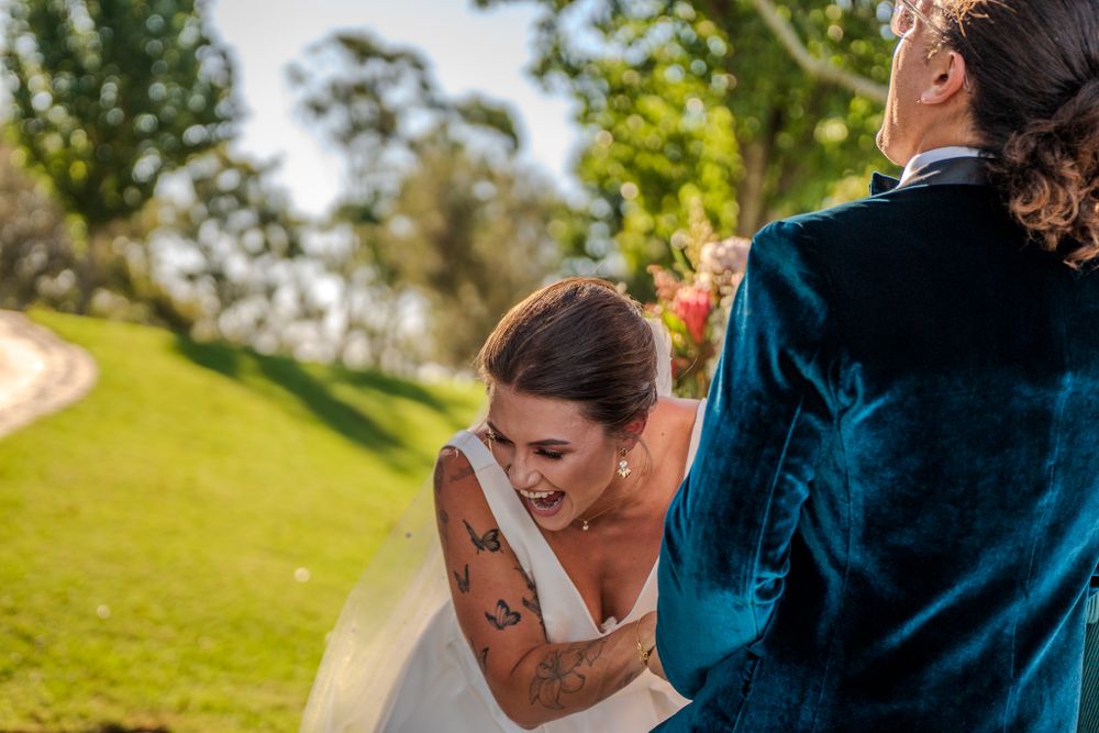 An emotional wedding ceremony moment outdoors on a sunny green lawn.