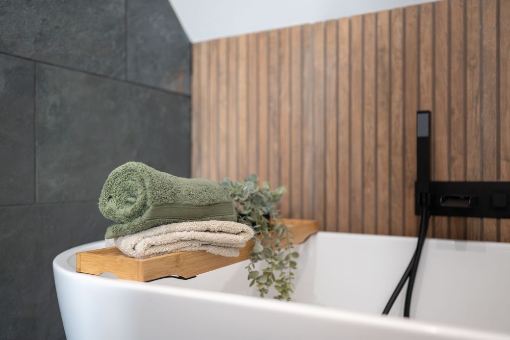 Modern bathroom interior with wooden slat wall panels and white fixtures creates a spa-like atmosphere.