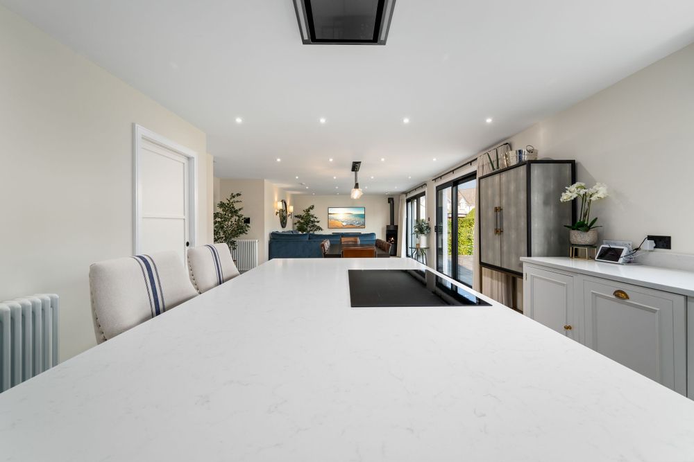 Contemporary open concept living space with recessed lighting and minimalist white walls.