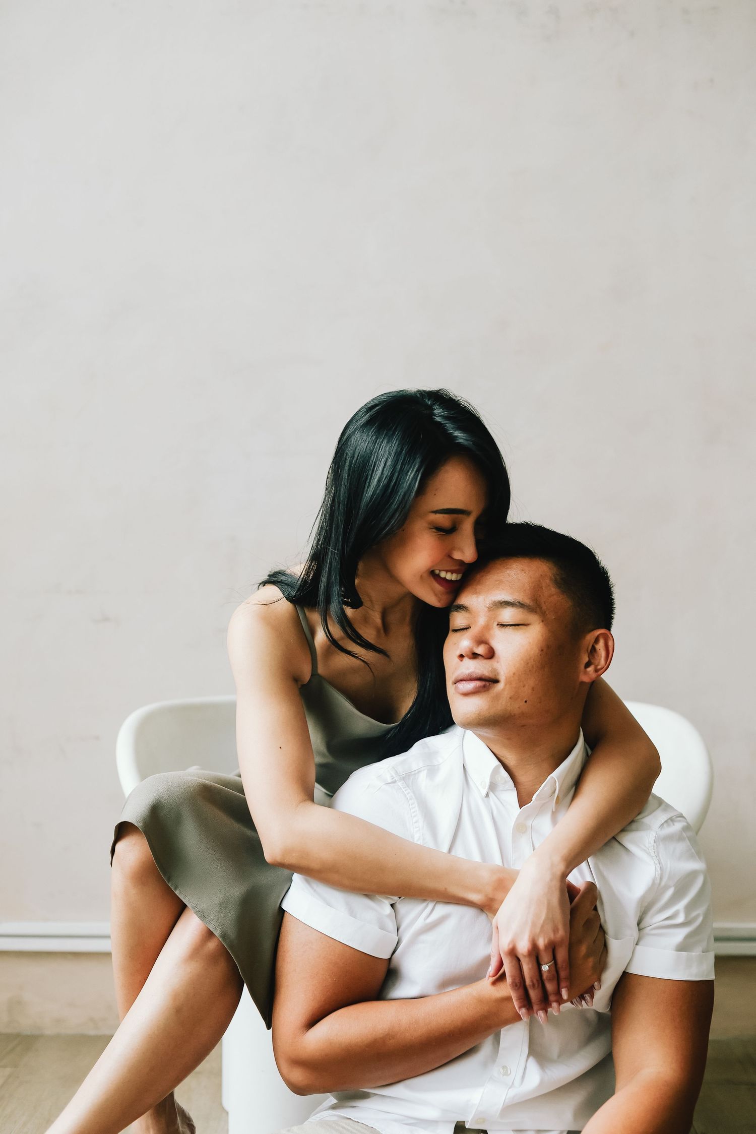 An intimate portrait of a couple sharing a tender moment while sitting together indoors.