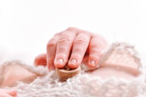 Close-up of gentle hand touching delicate lace fabric in soft lighting.