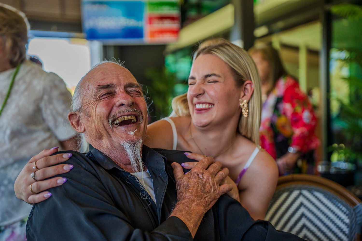A touching moment of shared laughter between two people in a casual indoor setting.