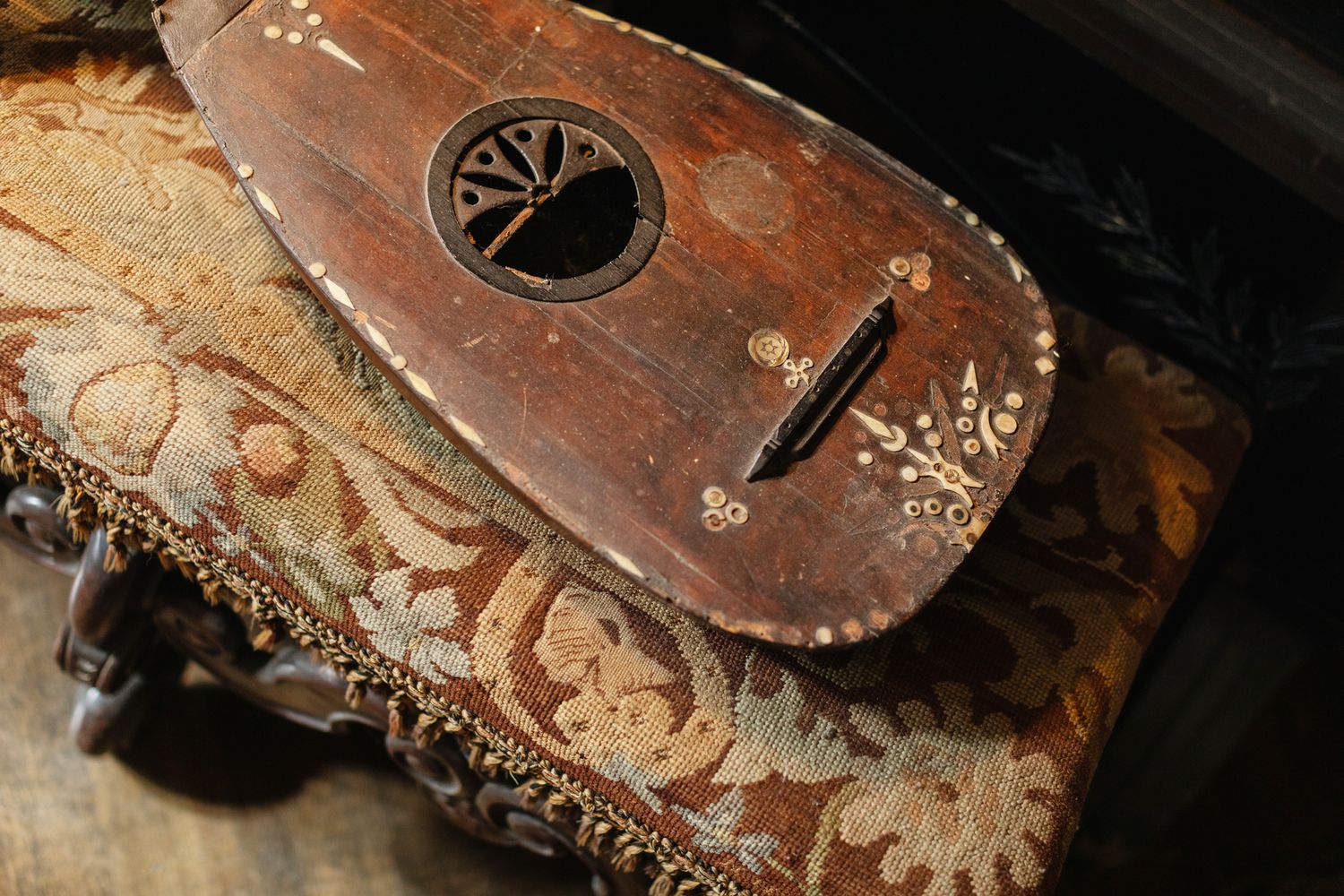 Antique violin lays on antique footstool. Massachusetts photographer.