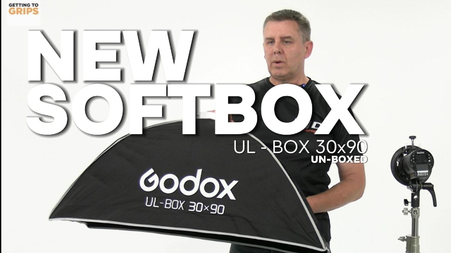 Man unboxing a Godox UL-BOX 30x90 softbox, demonstrating the new photography lighting equipment on camera.