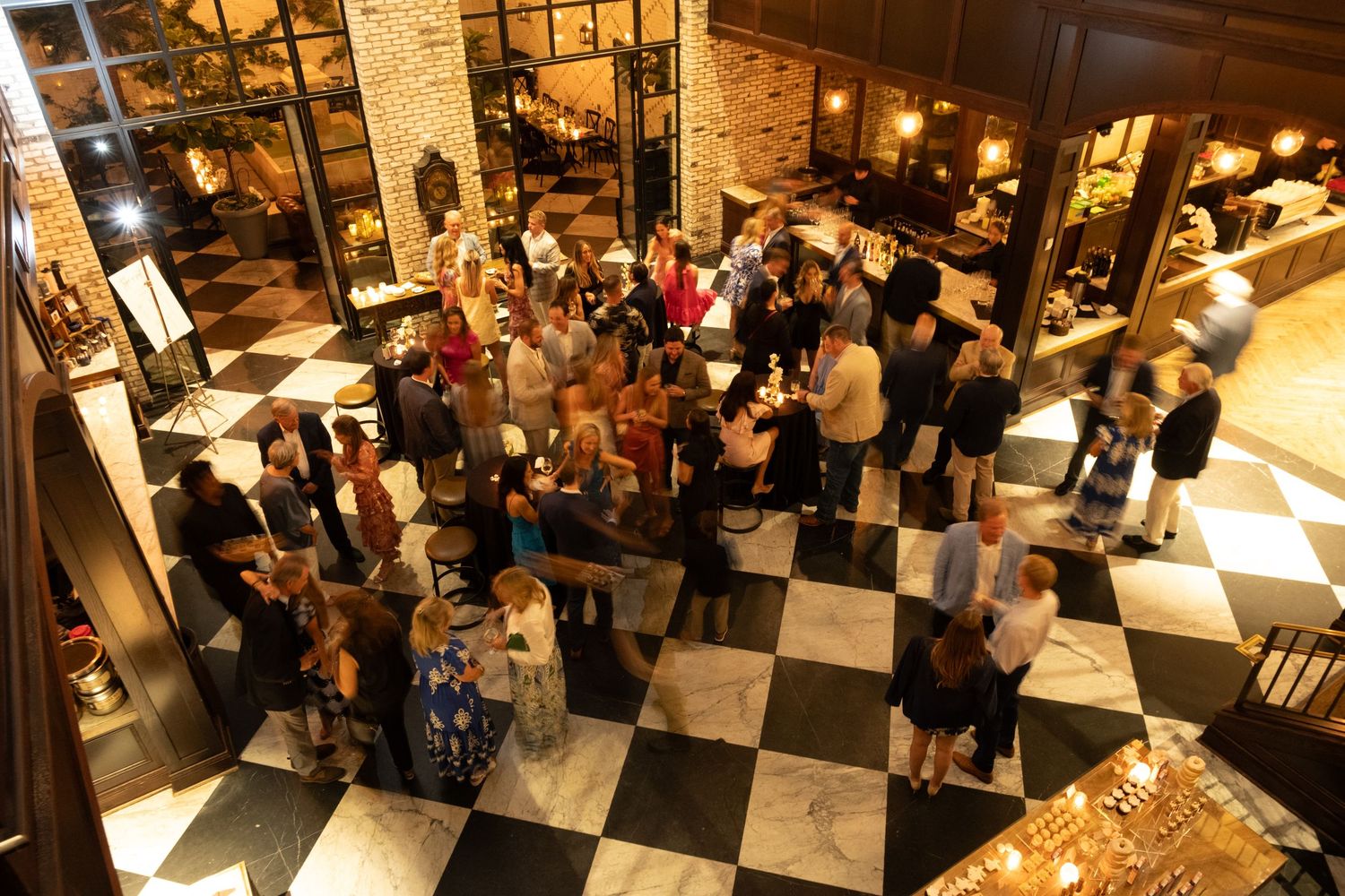 Guests mingling during a rehearsal dinner at Oxford Exchange Tampa wedding venue
