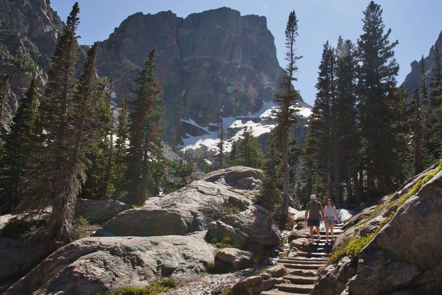 Couple descending from an Emerald Lake proposal in Rocky Mountain National Park. Photographer: Pixcapades