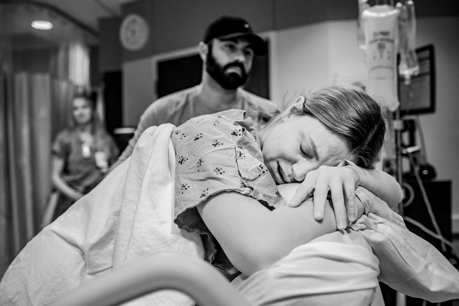 A woman in transition at Methodist Women's Hospital in Omaha leans over the back of the hospital bed with a tear falling on her nose.