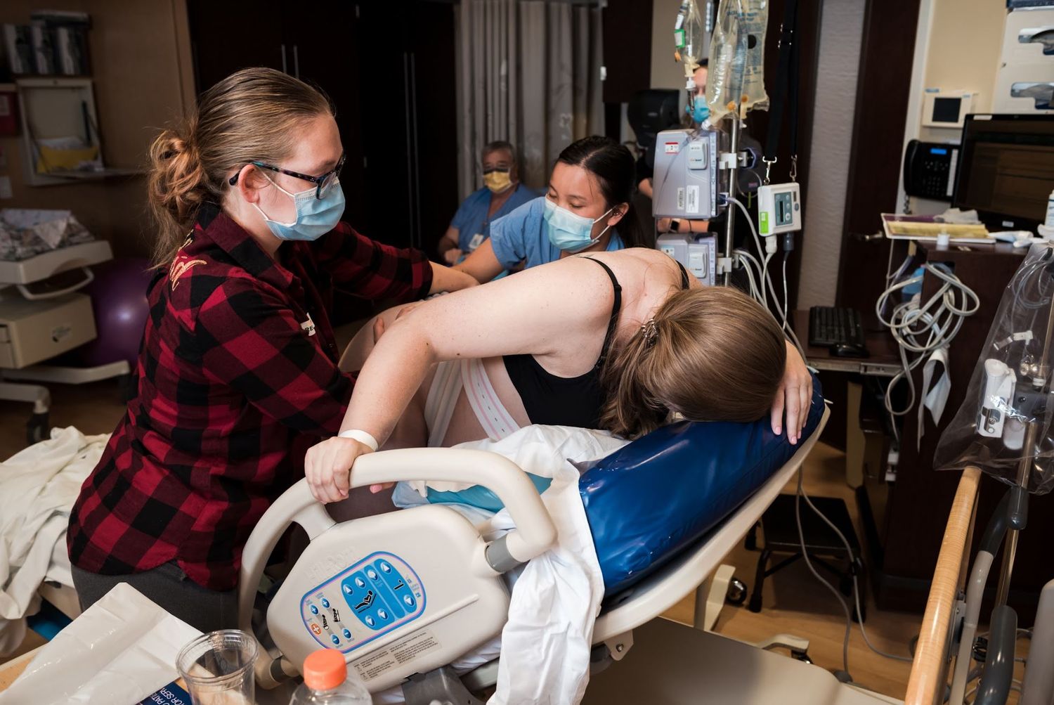 Healthcare team and sister assists mother during labor
