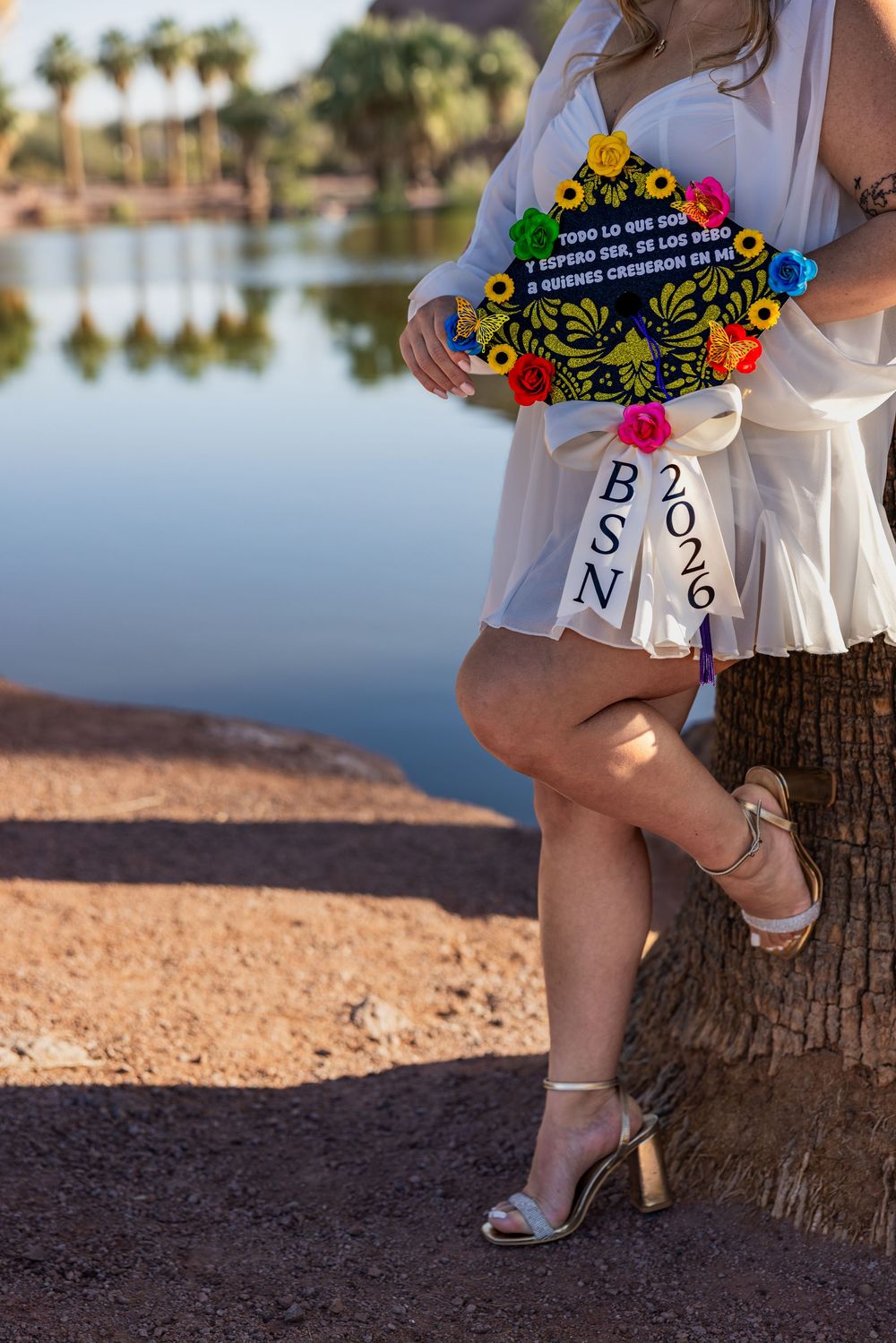 Close-up of decorated BSN 2026 graduation cap with colorful flowers held by graduate.