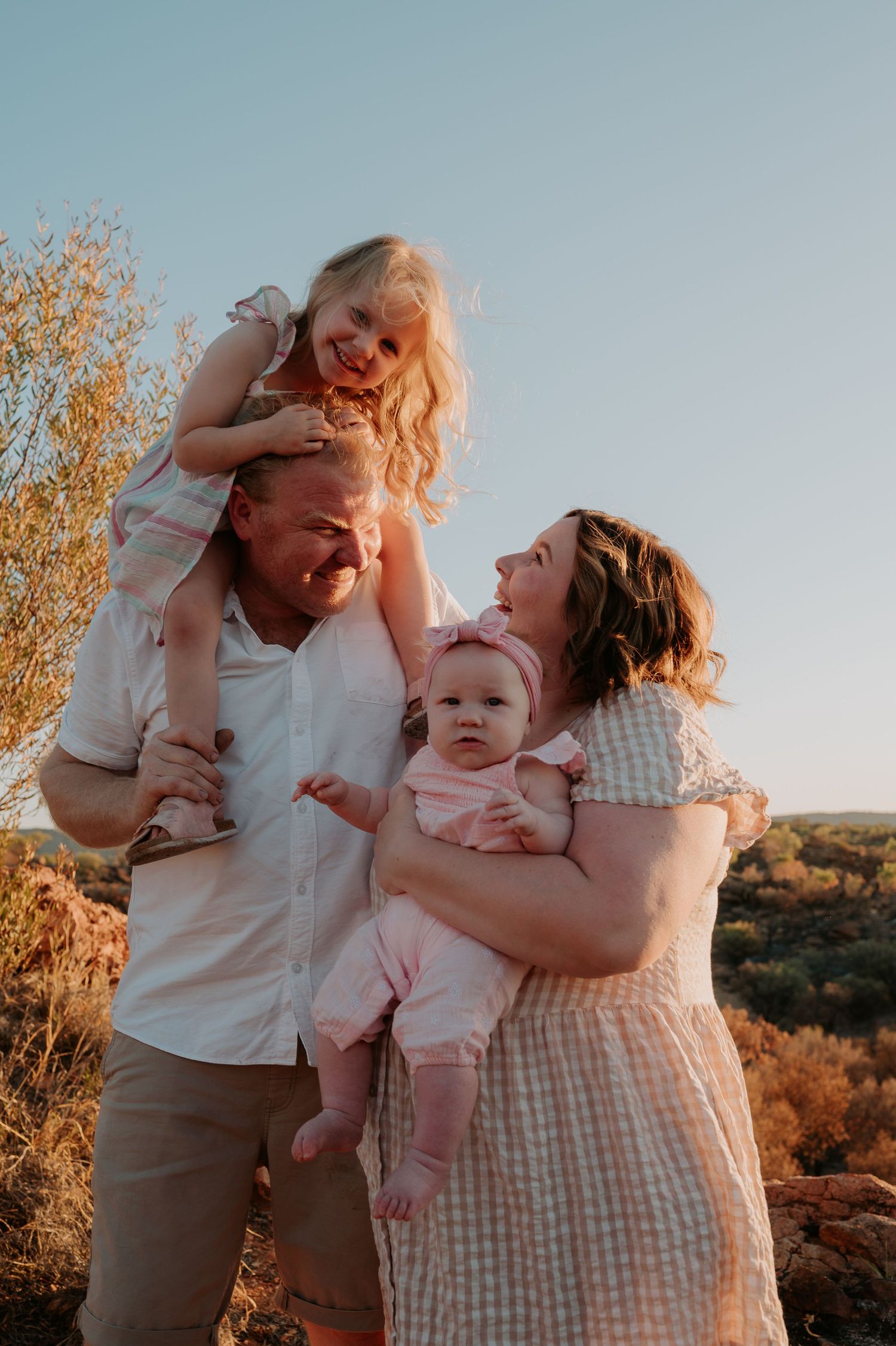 family of four, the father has his eldest daughter on his shoulders while mum holds the baby - Alice Springs