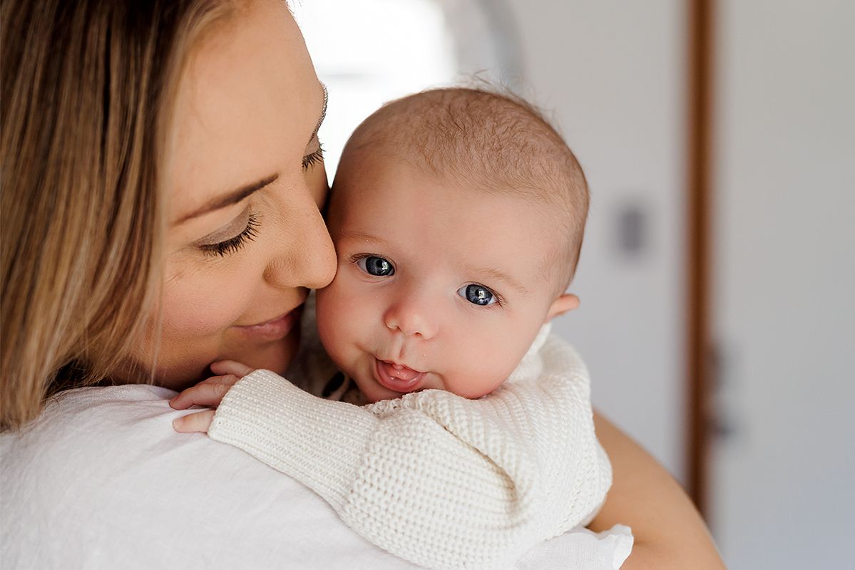 Newborn photography Adelaide — mother holding newborn in natural window light, in-home session Mawson Lakes — Photo By Nancy