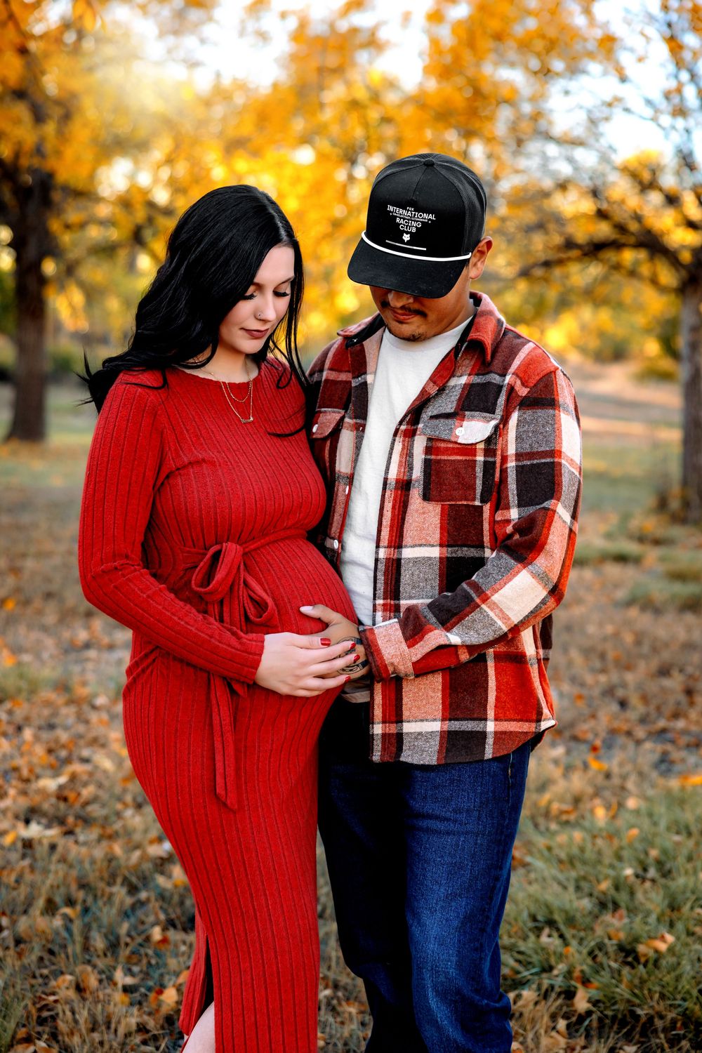 A couple shares an intimate moment outdoors during autumn. Pueblo Maternity Photographer