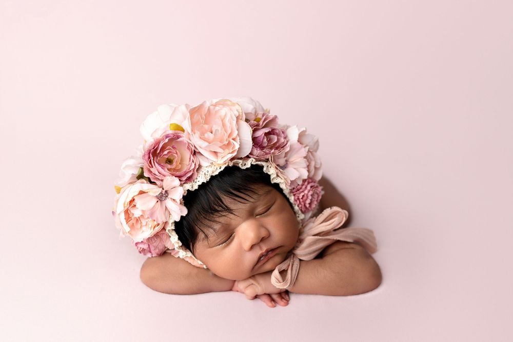 Newborn photography collage showing sleeping baby in pink tones with floral decorations and soft blankets.