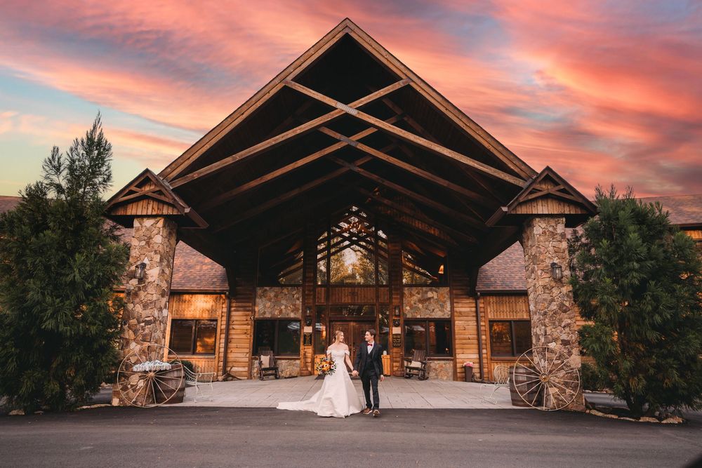 Bride and groom walking in front of the lodge at Lydia Mountain Lodge at sunset
