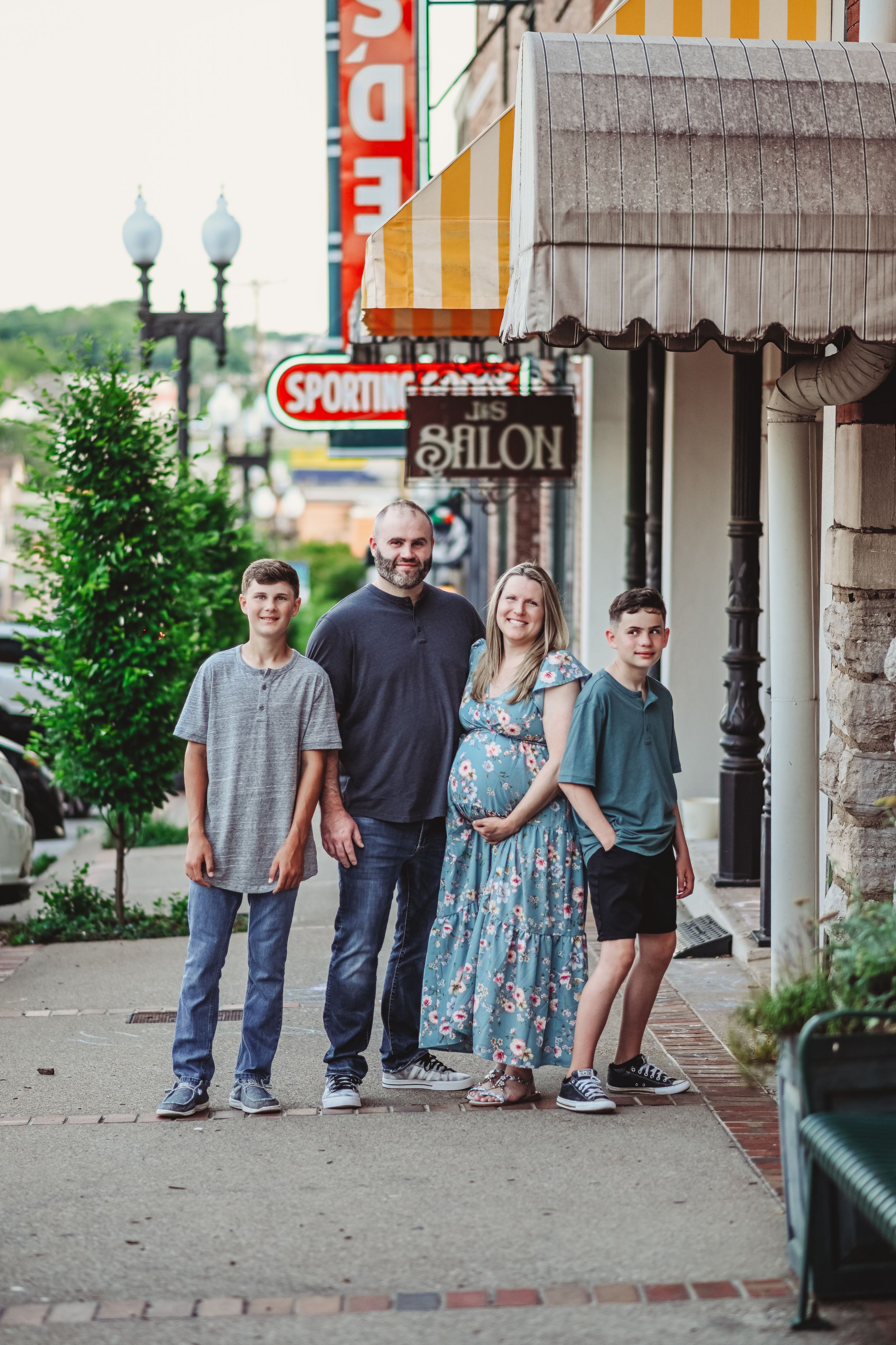 A family portrait on a small-town sidewalk with vintage storefronts in the background.