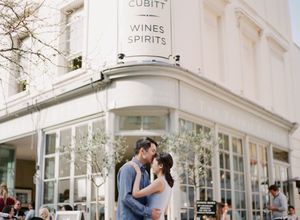 A couple shares a tender kiss outside the Cubitt Wines and Spirits shop in London.