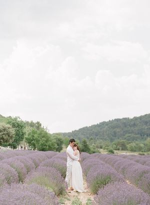 Couple embracing romantically in a stunning purple lavender field with rolling hills in Provence.
