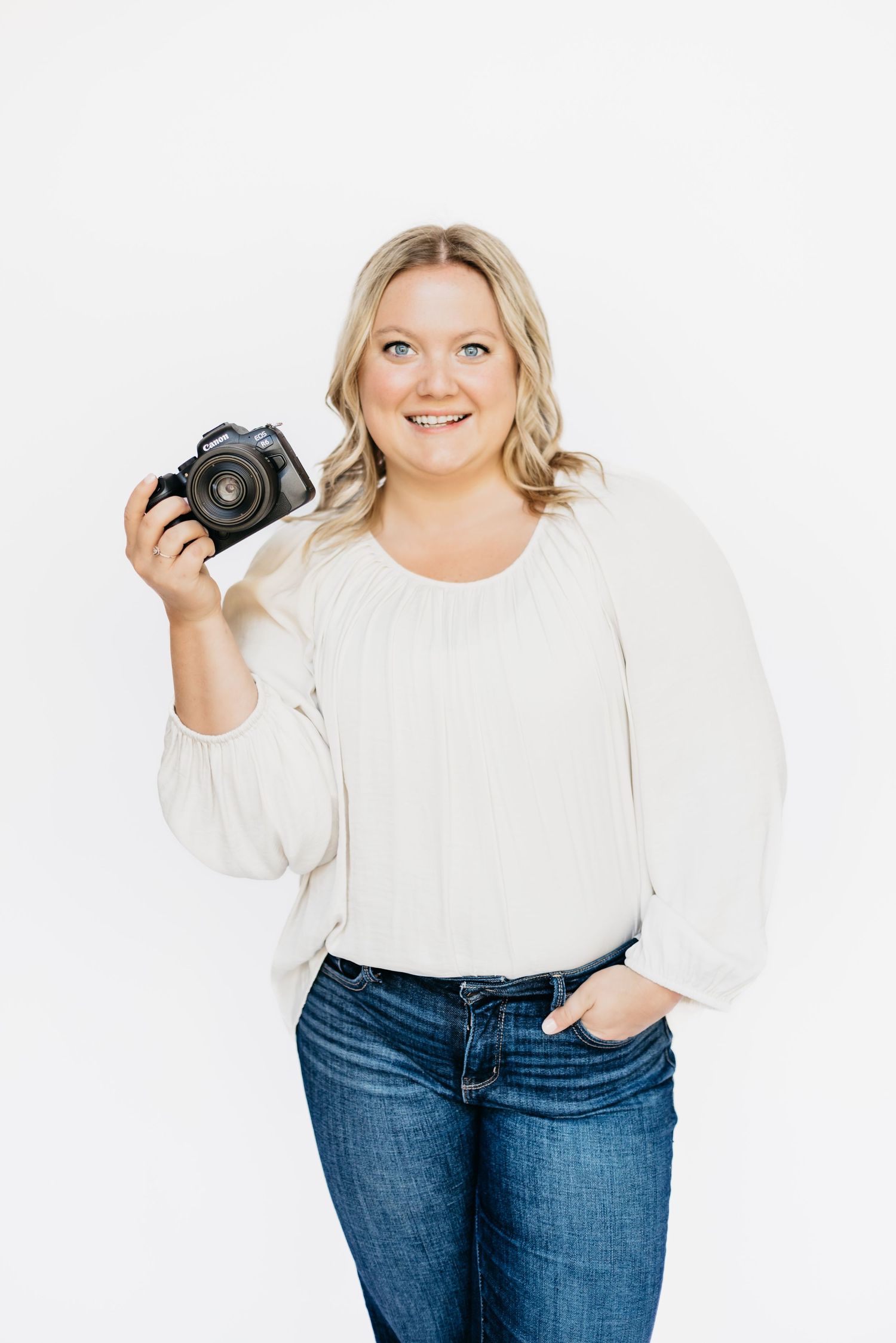 Cheerful blonde photographer in white top