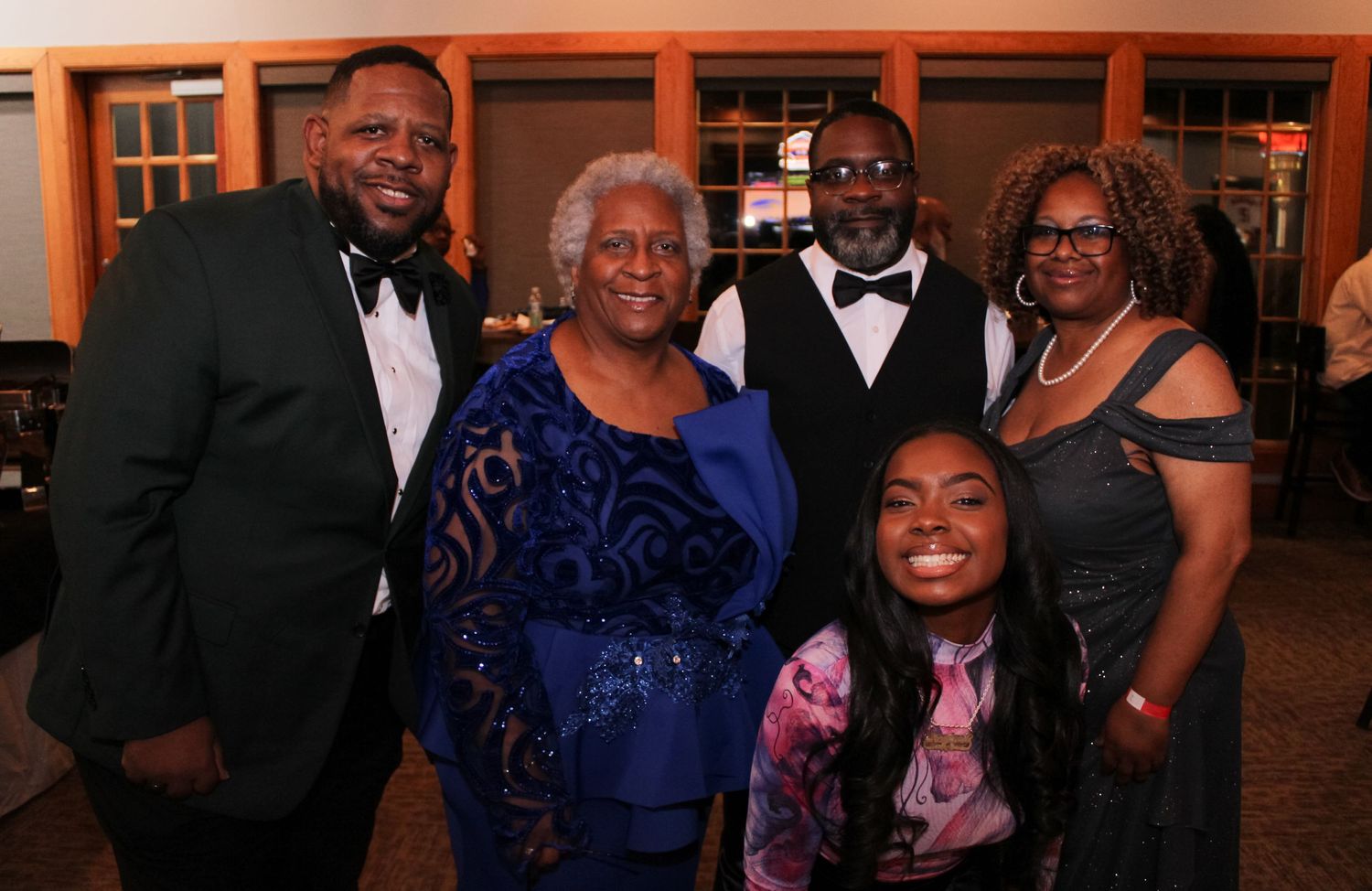 Group photo at a formal event with people wearing elegant evening attire.