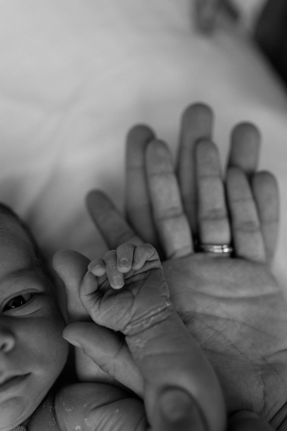 Close-up sequence of hands showing wedding rings in black and white photography.