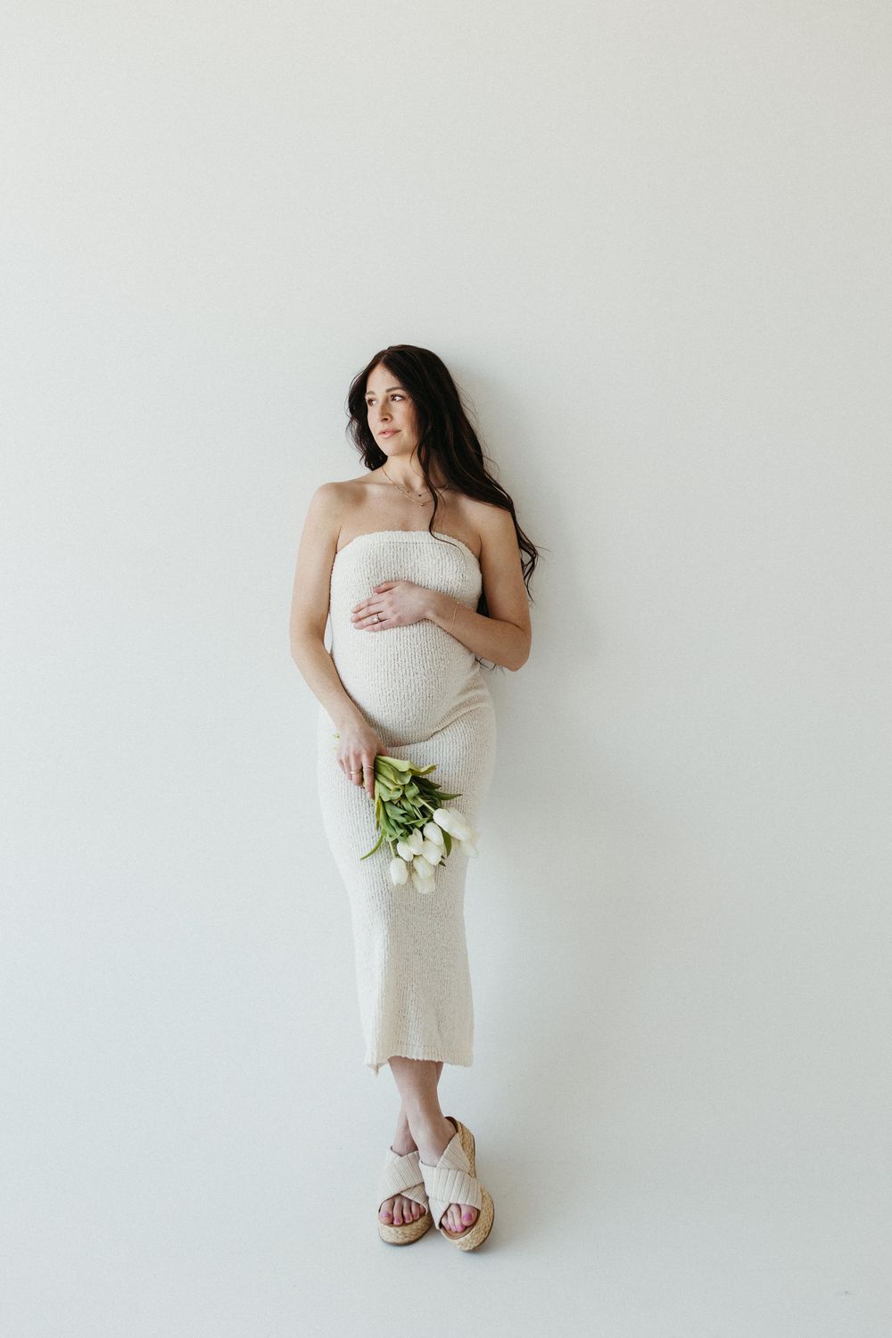 A series of minimalist bridal portraits against a white background showing a white dress and bouquet.