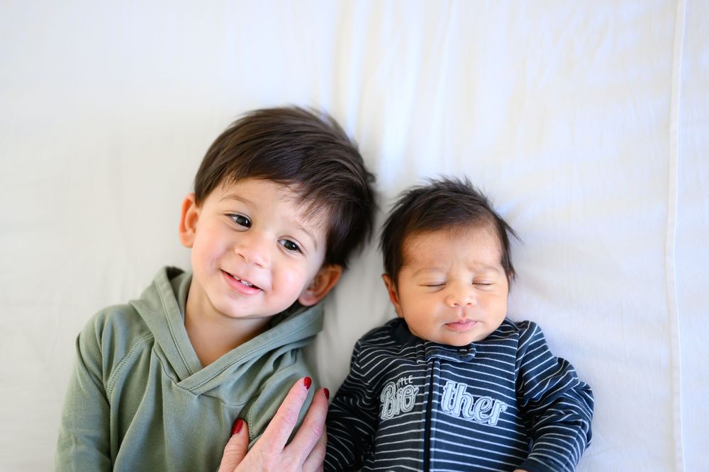 Two young children in casual clothing sitting together and smiling warmly.